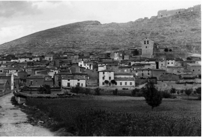 Foto en blanco y negro de un castillo en una montaÒaDescripciÛn generada autom·ticamente con confianza media