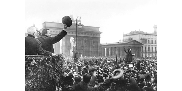 Fotografía en blanco y negro de una manifestación con miles personas en la puerta de Brandemburgo.
